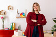 © Tania Cervian/Stocksy - Happy entrepreneur standing in office with arms folded
