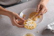 © Anna Fedorova/Stocksy - Hands spread fresh vegan cheese on round puffer corn cake