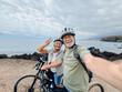 © Daniel - Two happy old mature people enjoying and riding bikes together to be fit and healthy outdoors. Active seniors having fun taking a selfie picture with camera