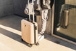 © Diego Martin/Stocksy - Casual Man with Suitcase Leaning Against Building