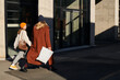 © Irina Bo/Stocksy - A mother and daughter in autumn clothes walk near a modern building.