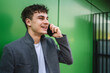 © Miljan Živković - young handsome man talk on mobile phone on the green wall background