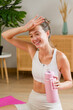 © mahalo studio/Stocksy - woman wiping sweat after home workout session