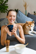 © mahalo studio/Stocksy - woman drinking tea with her dog at home