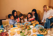 © Evgeniia Siiankovskaia/Stocksy - Festive Hanukkah table with traditional food and family at it.