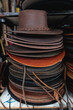 © Dani Nahuel/Stocksy - Pile of brown leather hats for sale