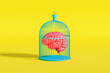 © Marcos Osorio/Stocksy - Brain encapsulated in a cage against a bright yellow background