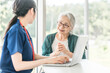 © buritora - 看護師・女性ケアマネージャーに体調の説明をするシニア女性