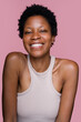 © mahalo studio/Stocksy - woman smiling on pink background