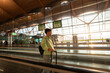 © Alvaro Lavin/Stocksy - Young tourist walking on moving walkway in airport terminal at sunset