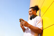 © Artem Podrez/Stocksy - Man with Headphones Checking Phone