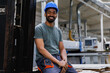 © Jovo Jovanovic/Stocksy - Smiling male industry worker sitting on forklift