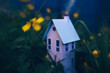 © Catherine MacBride/Stocksy - A little white paper craft house sits in a garden of buttercups