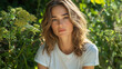 © JCreative - white woman T-shirt mockup concept. serene woman with wavy hair poses amidst lush greenery, exuding calmness