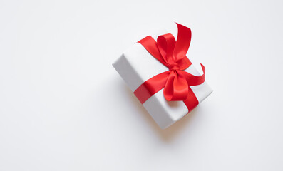 Wall Mural - simple white paper craft gift box with red ribbon bow in dynamic angle.anniversary and special day w