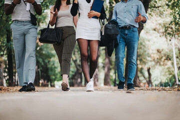 Wall Mural - A group of business people walking together outside, showcasing casual attire and engaged in conversation. The image captures a sense of teamwork and casual interaction in an outdoor setting.