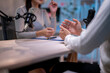 © Apichat - Two women are talking on a table with microphones