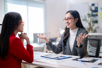 Wall Mural - Two women are talking in a business setting