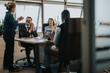 © qunica.com - A diverse group of business people applauding during a meeting in a modern office setting, highlighting teamwork, collaboration, and successful communication.