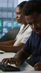 Poster - vertical video engineer in server room looking over documents, developing disaster recovery plans en