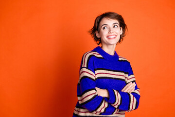 Poster - Photo of cute lovely woman crossed arms wear trendy winter sweater empty space isolated on orange color background