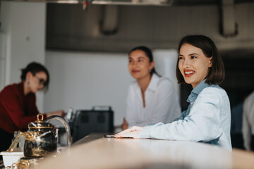 Wall Mural - Multicultural and multiracial business workers smiling and enjoying a casual break. The modern workspace atmosphere promotes relaxation and positivity among colleagues.