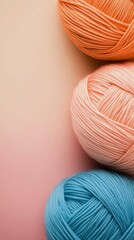 Wall Mural - Display of colorful yarn balls in pastel shades arranged on a soft pink background