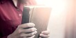 © Suchithra - A person holding a worn Bible, symbolizing faith and devotion