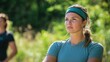 © PhotoStudioWizard - A woman wearing a green headband is standing in a field