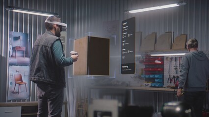 Fototapete - Modern workshop: Designer or artisan wearing augmented reality headset assembles coffee table in virtual space using app with AI user interface. 3D graphics of holographic furniture. VFX animation.