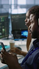 Poster - vertical video admin in server room using mobile phone, relaxing after ensuring minimal downtime. da