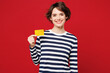 © ViDi Studio - Young smiling cheerful fun cool happy woman she wear blue striped sweatshirt casual clothes hold in hand mock up of credit bank card isolated on plain red background studio portrait Lifestyle concept