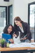 © Kritdanai - Collaborative Success: Two businesswomen, one Asian and one African American, work together on a project, a testament to the power of collaboration and diversity in the modern workplace.