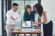 © Kritdanai - Business Professionals Analyze Data: A focused and collaborative team of diverse business professionals meticulously review data on a laptop and papers.