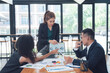 © Kritdanai - Business Meeting Analysis: A diverse team of professionals collaborates around a table, engaged in a business meeting with a focus on data analysis.