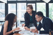 © Nittaya - Teamwork Makes the Dream Work: A diverse team of business professionals collaborates on a project, showcasing their synergy and dedication in a modern office setting.
