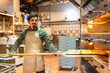 © unai - Baker working removing tasty pastries from the oven