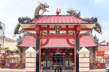 Gate of a klenteng in Solo with dragon snake ornaments and Chinese characters.