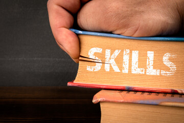 Wall Mural - skills concept. textbooks in a pile. human hand