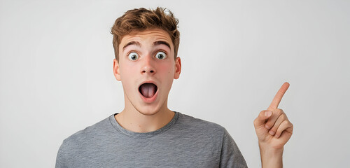 A young man showing a surprised expression and pointing right, isolated on a white background for use in modern advertising or social media content.