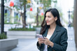 © MegastockStudio - Asian businesswoman engaged on phone urban lifestyle professional context modern environment candid viewpoint business concept