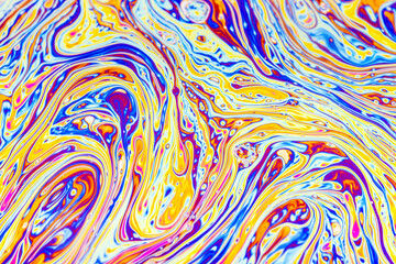 Real photograph of a colorful light interference on a soap bubble surface with random swirls, curves and lines