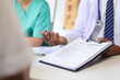 © Wasan - Health consultant from a team of medical experts in the hospital. Doctor talking with patient in examination room at hospital.