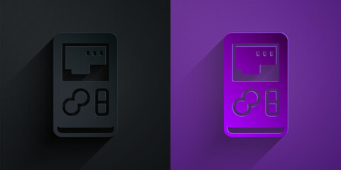 Poster - Paper cut Portable video game console icon isolated on black on purple background. Handheld console gaming. Paper art style. Vector