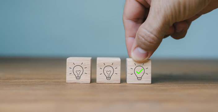 Concepts of suggestion and consultation.New answer. placing icons of wooden cubes with light bulbs on hand on blur background with copy space. company analysis and Recommendations for Company Strategy