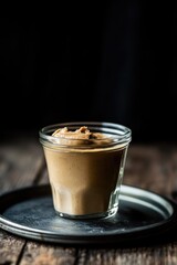 Poster - A single serving of coffee on a plate placed on a wooden table, perfect for a cozy morning or evening