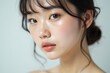 © vladrad - Close-up Portrait of a Young Asian Woman with Natural Makeup and Radiant Skin, Minimalist Background, Soft Lighting, Beauty and Skincare Concept