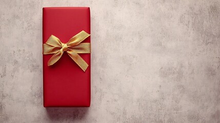 Poster - Minimalistic photograph of a slim rectangular matte red gift box tied with a golden ribbon isolated on a light gray background with soft lighting and ample copy space