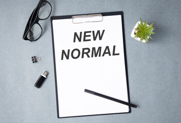 Wall Mural - New normal concept effected by COVID 19 coronavirus that changes our lifestyle to new normal presented in word written in notebook on office desk when abnormal becomes new normal .