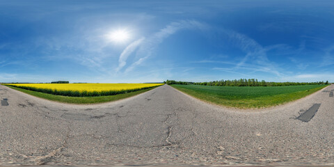 Wall Mural - spherical 360 hdri panorama on old asphalt road with cracks near rapeseed canola colza fields with c